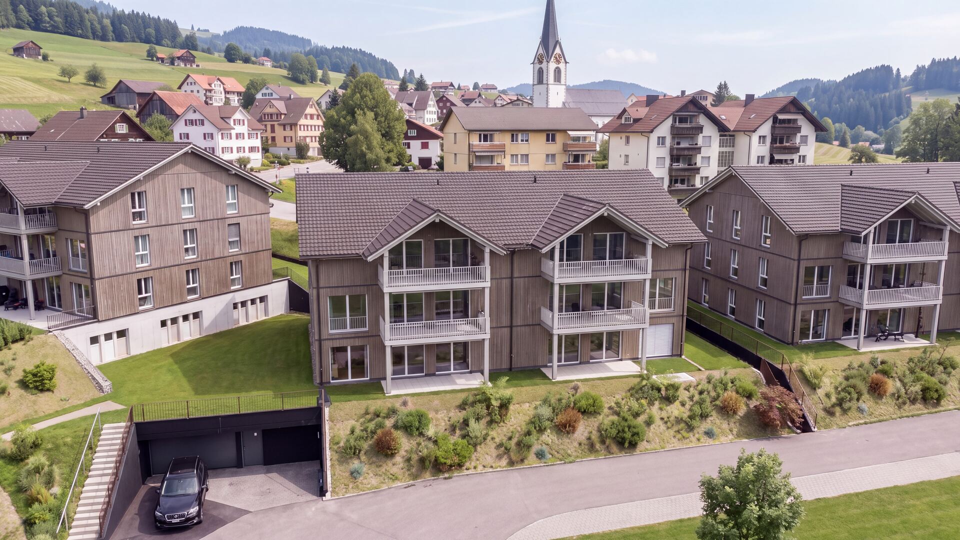 Visualisierung Haus 2 der Überbauung Kalkofen in Oberegg, im Hintergrund das Dorf mit Kirche